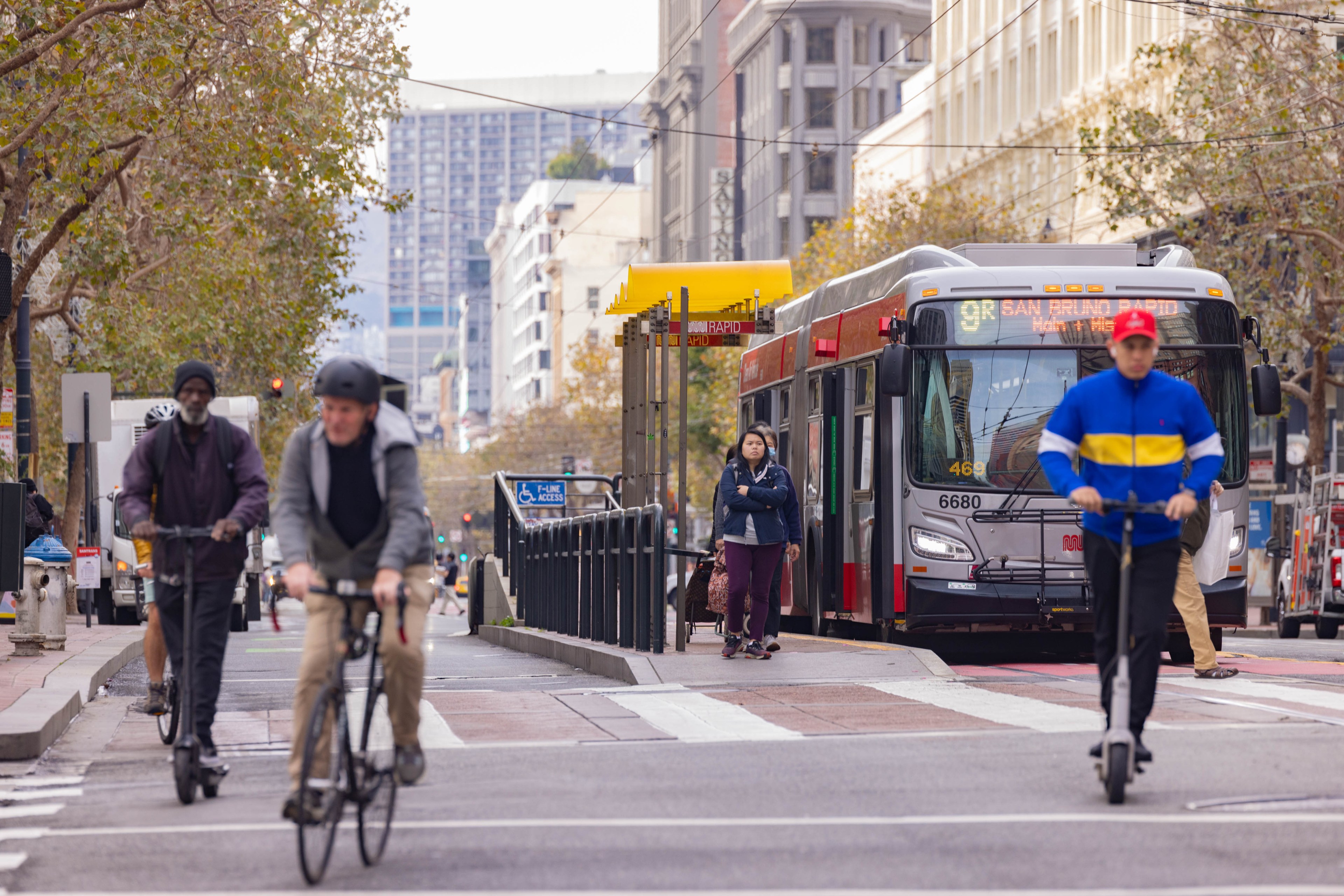 Bicyclists and scooter riders make their way down Market St.